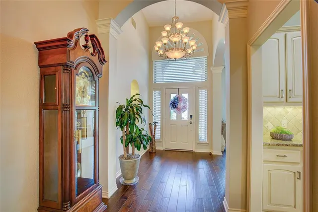 a view of a hallway with wooden floor and a dining room