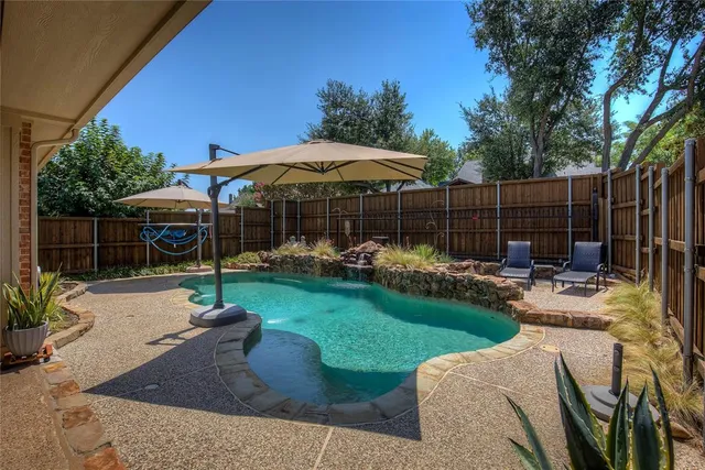 a patio with a table and chairs under an umbrella