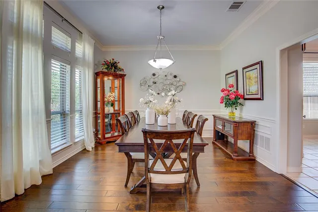 a dining room with furniture a chandelier and wooden floor