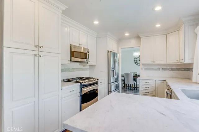 a kitchen with granite countertop a refrigerator stove and sink