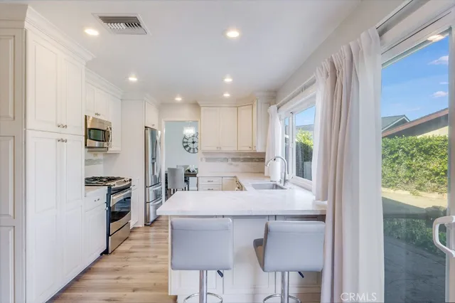 a kitchen with stainless steel appliances kitchen island granite countertop a refrigerator and a sink
