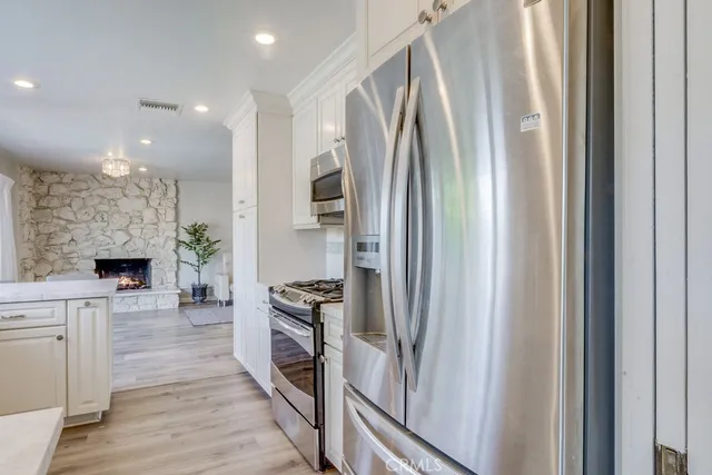 a kitchen with stainless steel appliances a refrigerator and a fireplace