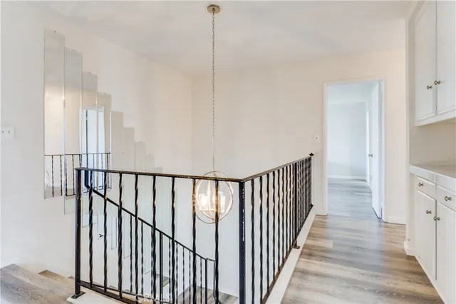 a view of a hallway with wooden floor and stairs