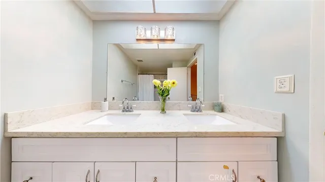 a bathroom with a granite countertop sink and a mirror