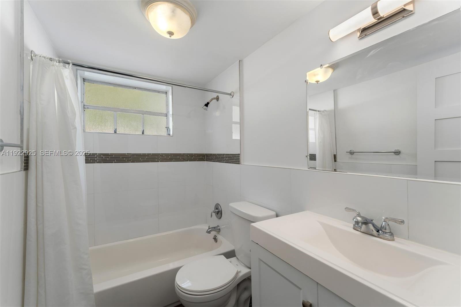 201 Galen Drive, Unit 104 Key Biscayne, FL 33149 - Photo 11 of 17 a bathroom with a bathtub shower sink vanity and toilet