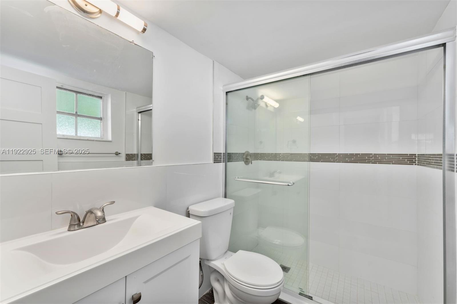 201 Galen Drive, Unit 104 Key Biscayne, FL 33149 - Photo 13 of 17 a bathroom with a sink a toilet and a mirror