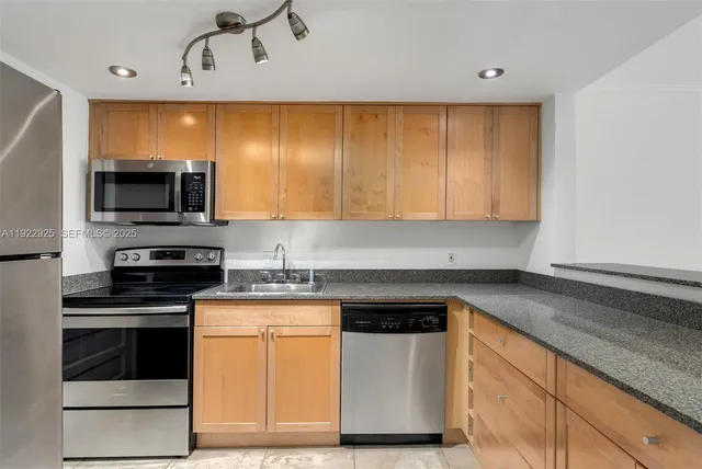 a kitchen with granite countertop a stove and a microwave