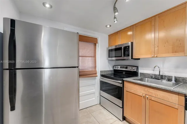 a kitchen with stainless steel appliances a refrigerator sink and microwave