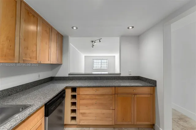 a kitchen with granite countertop cabinets sink and window