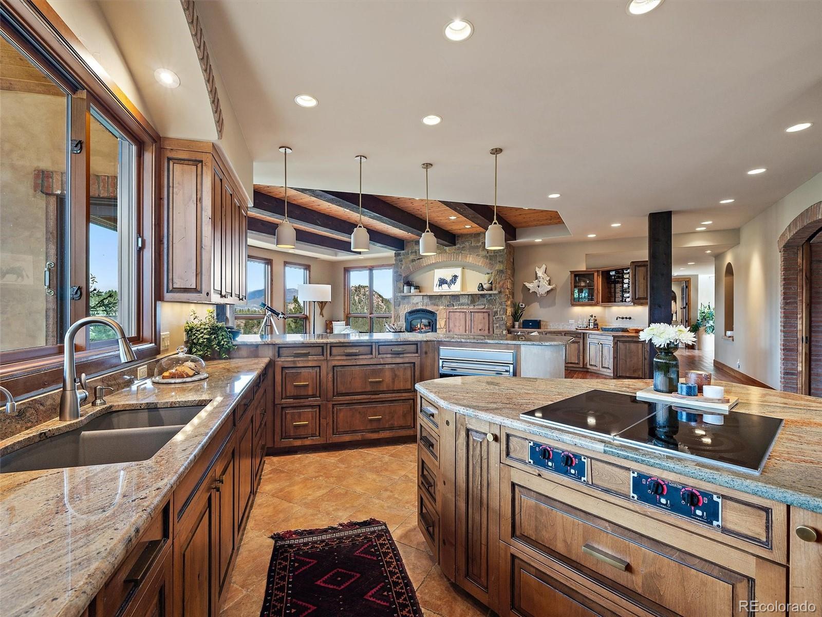 32024 Snowshoe Road Evergreen, CO 80439 - Photo 17 of 50 a kitchen with stainless steel appliances granite countertop a sink stove and refrigerator