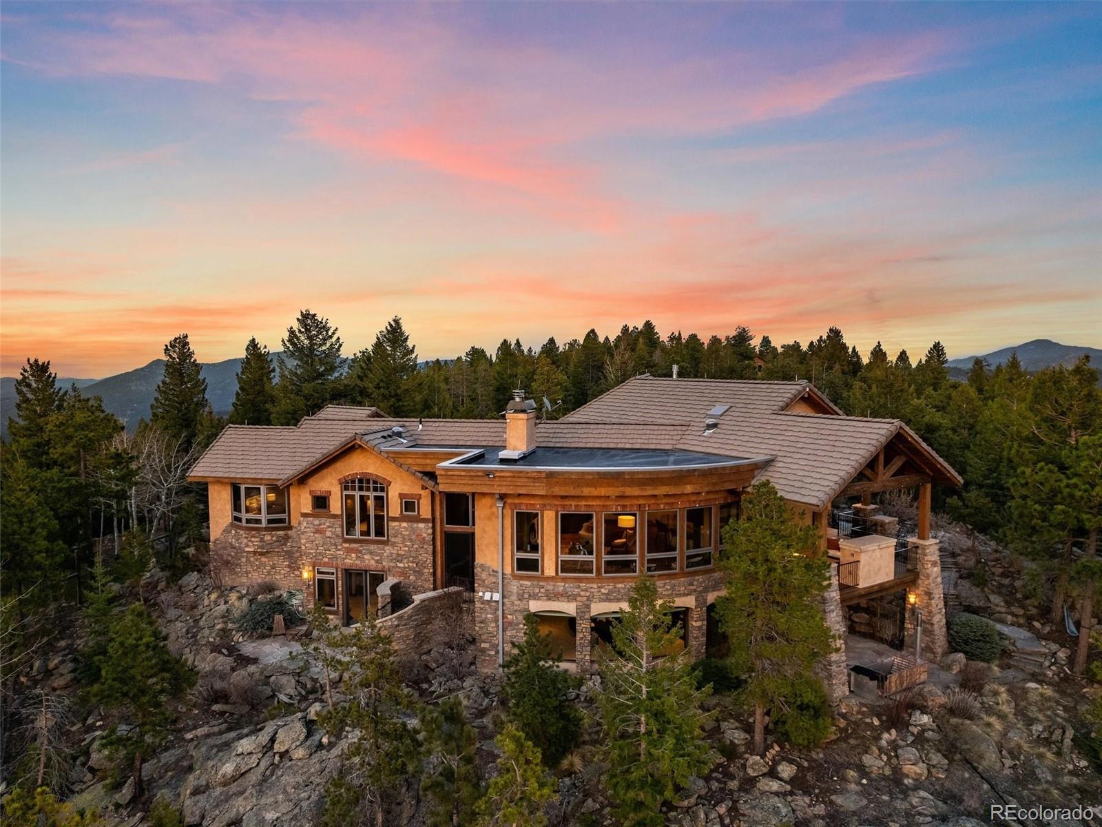 32024 Snowshoe Road Evergreen, CO 80439 - Photo 2 of 50 a aerial view of a house with a big yard and large trees