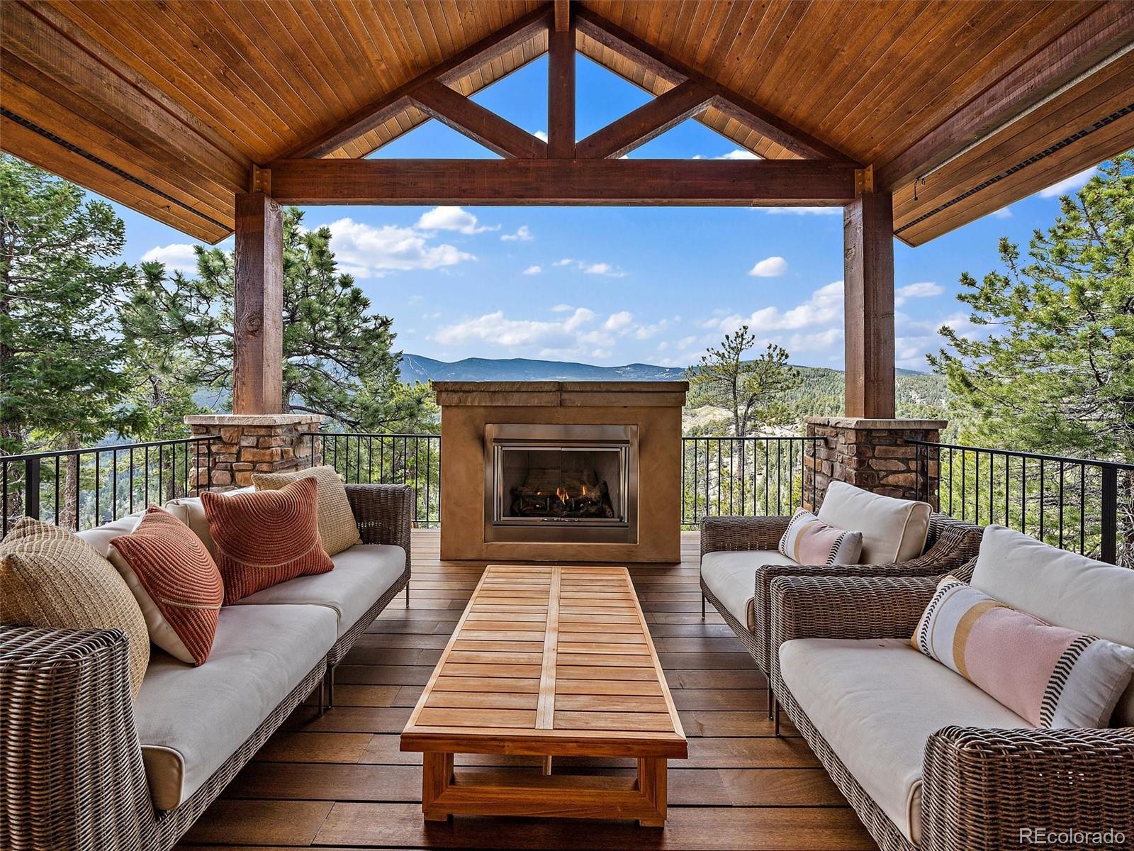32024 Snowshoe Road Evergreen, CO 80439 - Photo 21 of 50 a balcony with furniture and a fireplace