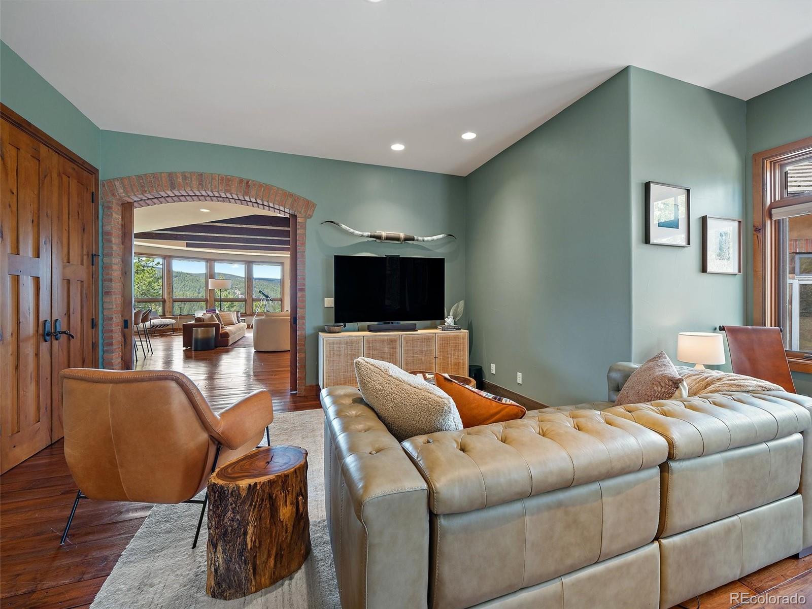 32024 Snowshoe Road Evergreen, CO 80439 - Photo 23 of 50 a living room with furniture a flat screen tv and a large window