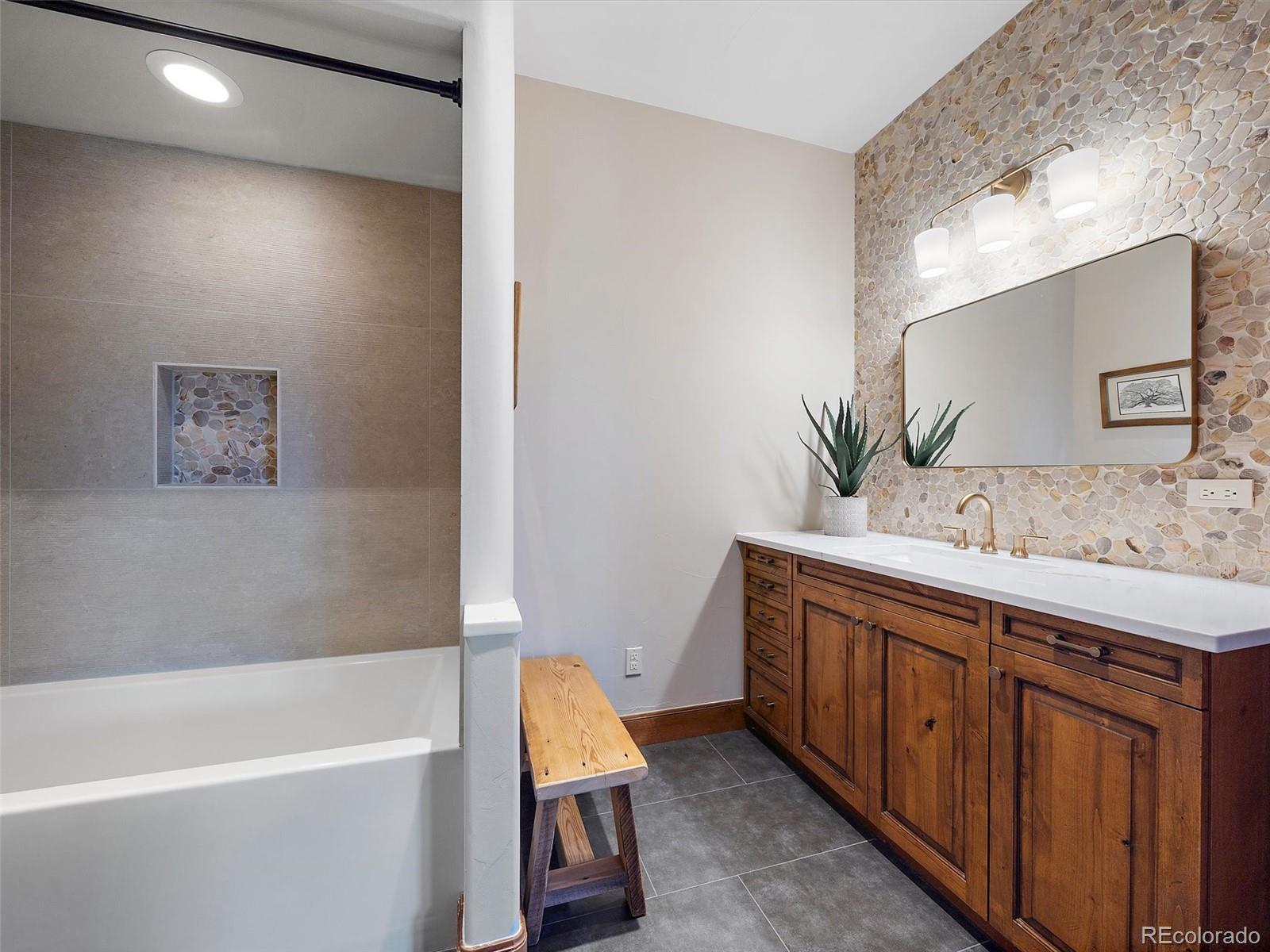 32024 Snowshoe Road Evergreen, CO 80439 - Photo 38 of 50 a bathroom with a tub sink and mirror