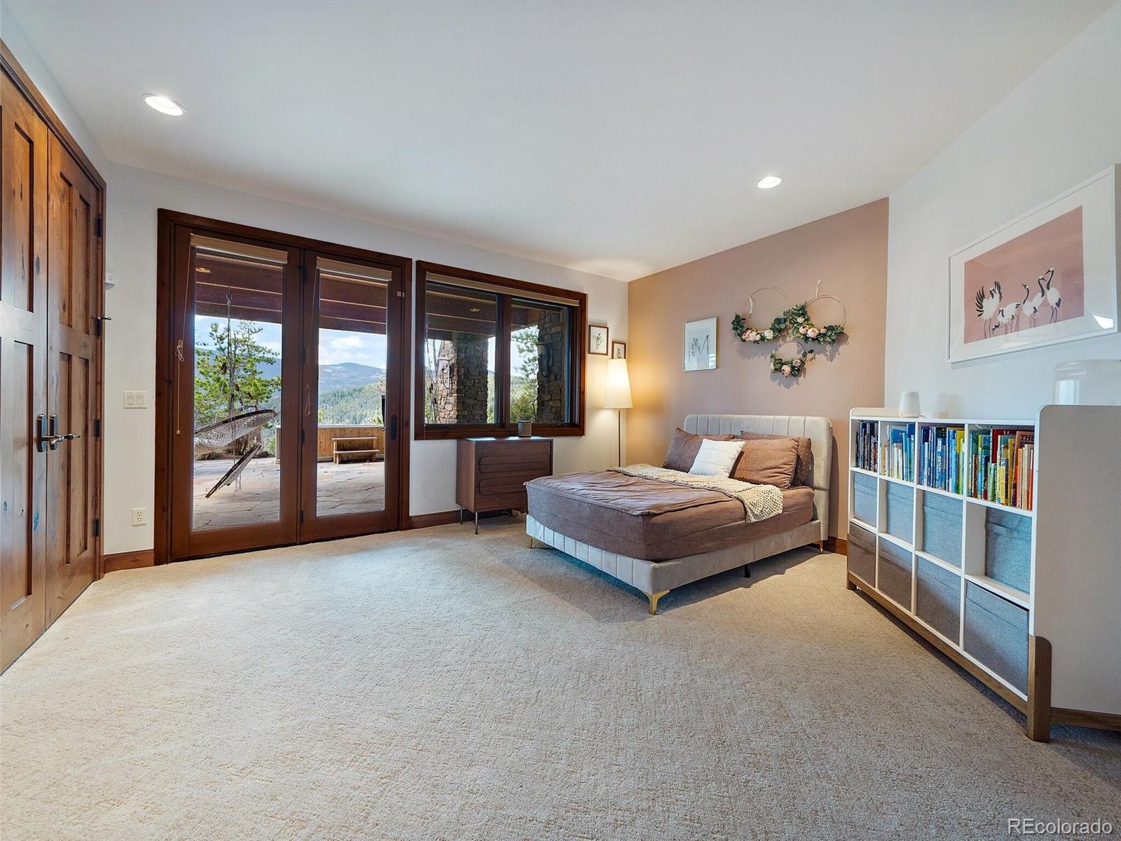 32024 Snowshoe Road Evergreen, CO 80439 - Photo 39 of 50 a spacious bedroom with a large bed and a large window