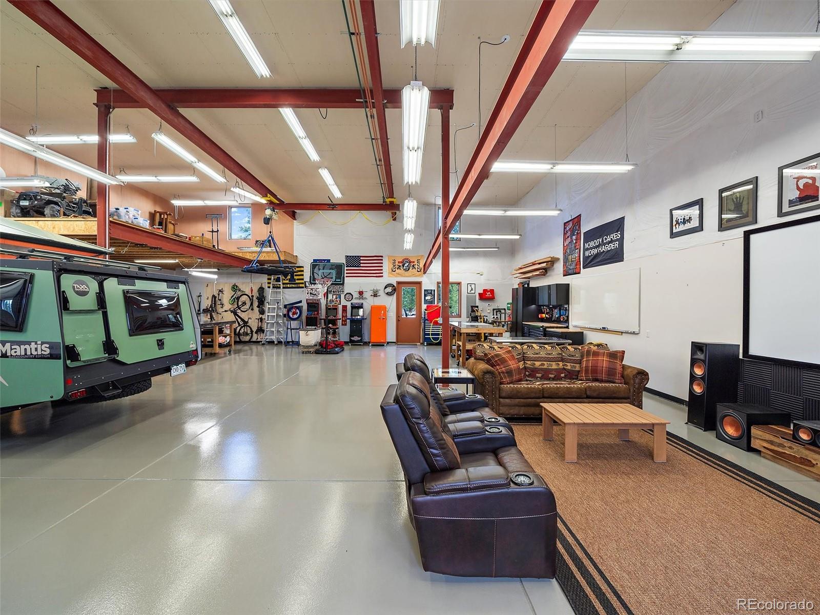 32024 Snowshoe Road Evergreen, CO 80439 - Photo 45 of 50 a gym room with lots of furniture and a flat screen tv