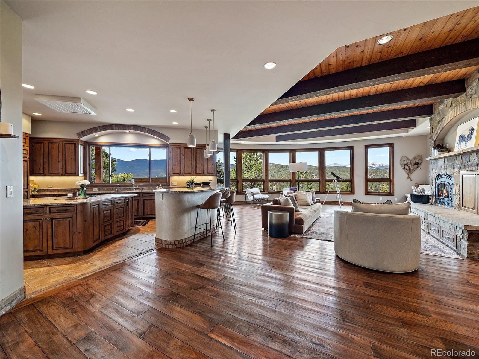 32024 Snowshoe Road Evergreen, CO 80439 - Photo 5 of 50 a living room with lots of furniture and kitchen view