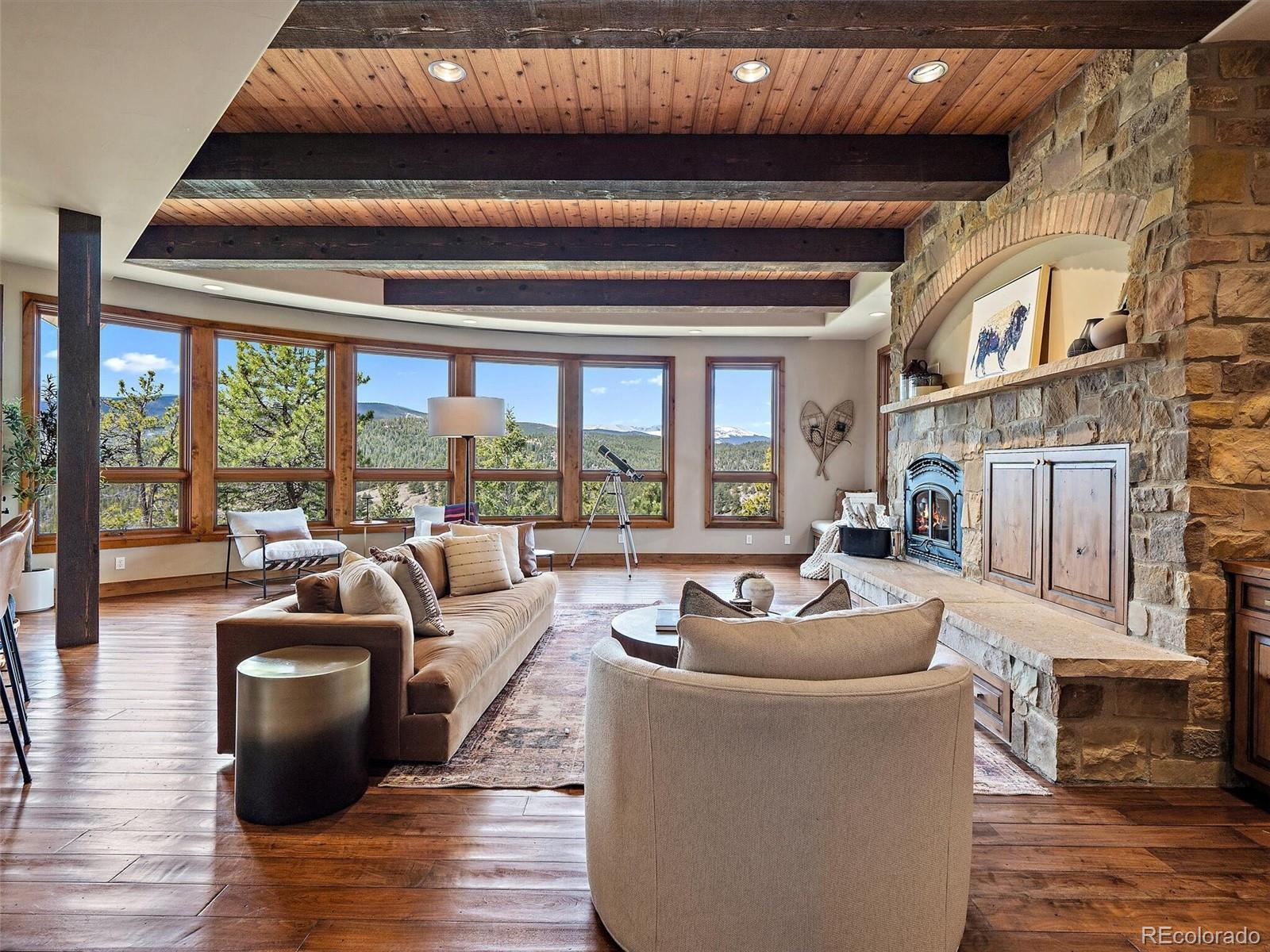 32024 Snowshoe Road Evergreen, CO 80439 - Photo 6 of 50 a living room with furniture and a fireplace