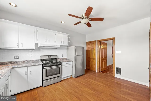a kitchen with stainless steel appliances granite countertop a stove a sink and a refrigerator