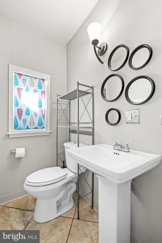 a bathroom with a toilet a sink and mirror