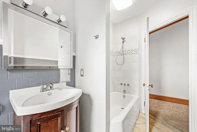 a bathroom with a sink a mirror and a bathtub