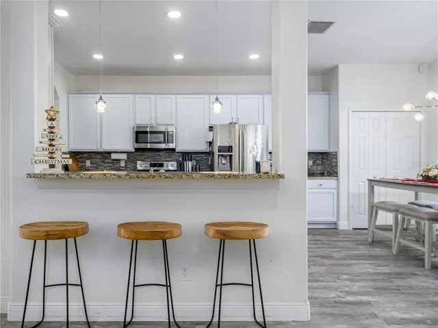 a kitchen with stainless steel appliances granite countertop a stove a sink and a refrigerator