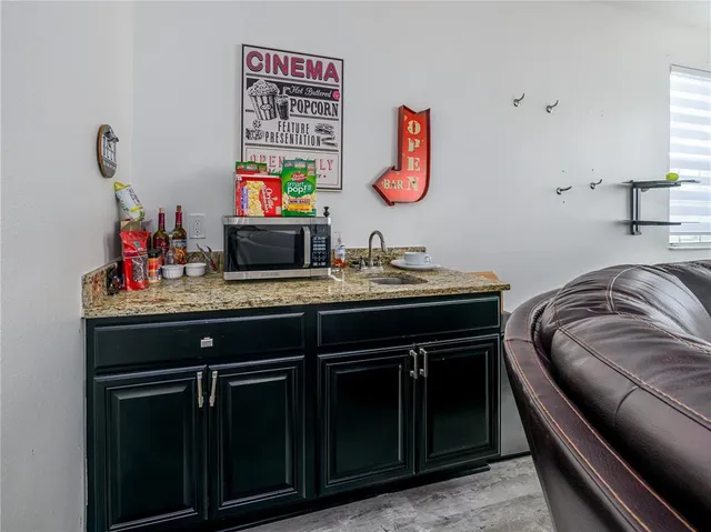 a bedroom with a bed a mirror on dresser and a flat screen tv