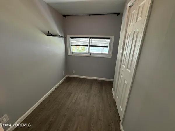 a view of a hallway with wooden floor and a window