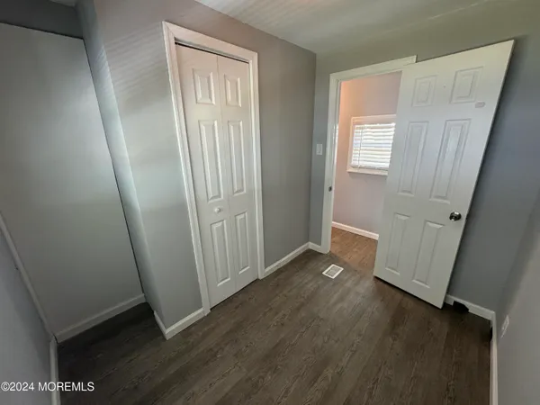 an empty room with wooden floor and window