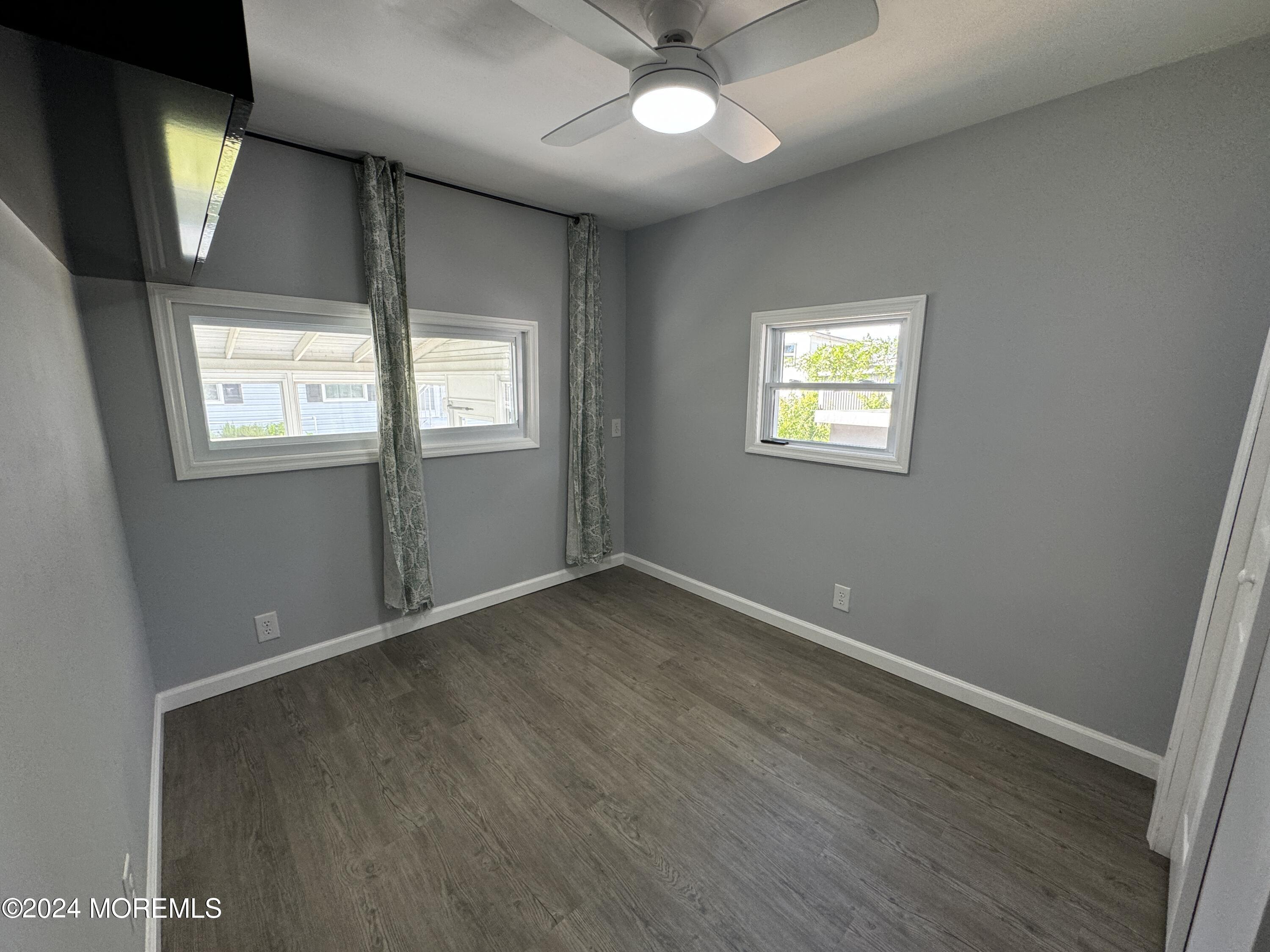 422 4th Street Jackson, NJ 08527 - Photo 14 of 17 an empty room with wooden floor and windows