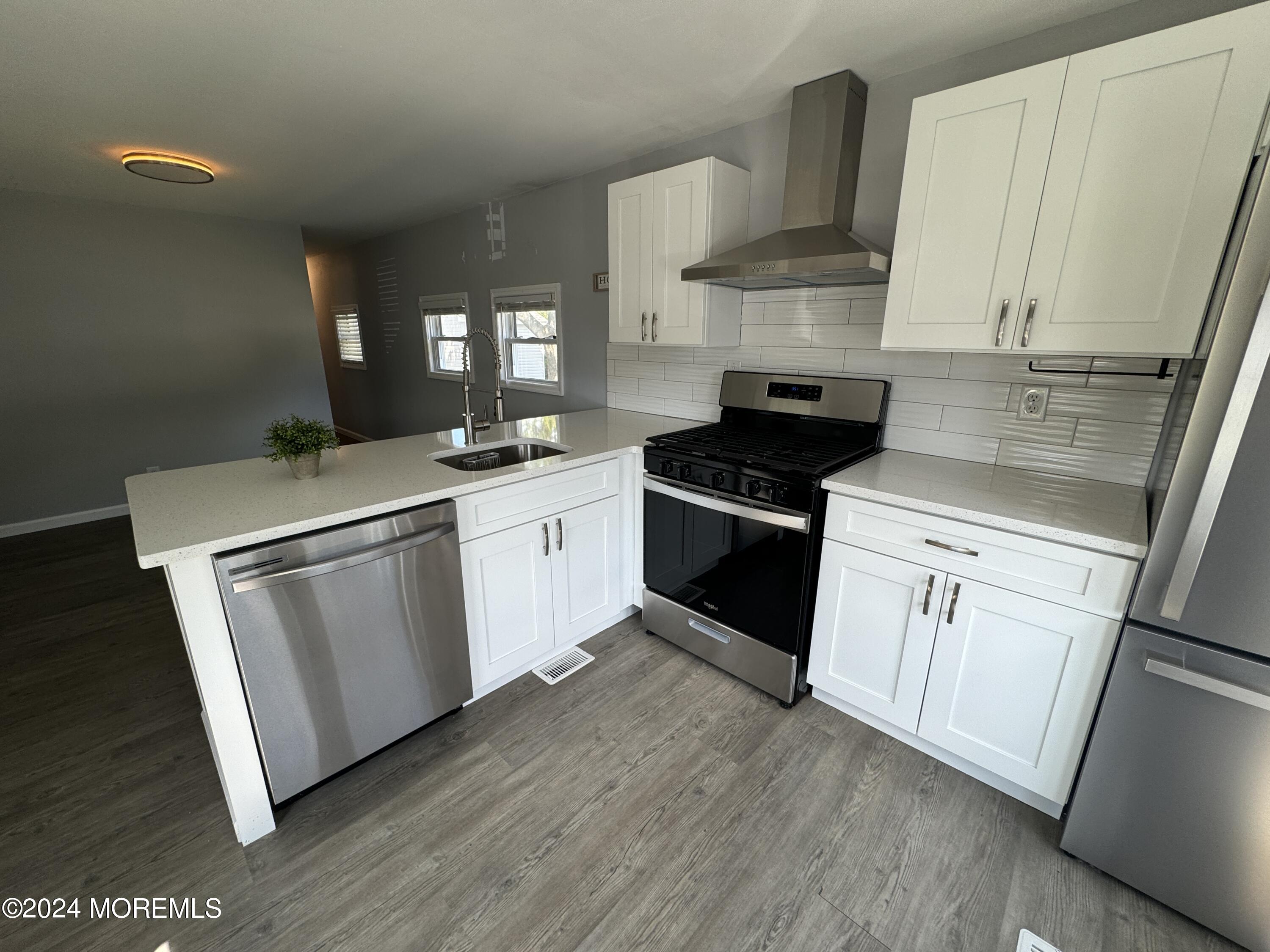 422 4th Street Jackson, NJ 08527 - Photo 5 of 17 a kitchen with white cabinets appliances and wooden floor