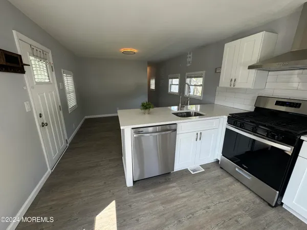 a kitchen with granite countertop a sink stove and refrigerator