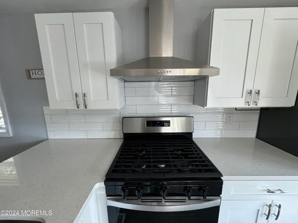 a stove top oven sitting inside of a kitchen