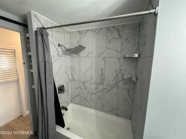 a bathroom with a shower and a bath tub
