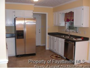 4938 Black Bridge Road Parkton, NC 28371 - Photo 4 of 17 a kitchen with a refrigerator and a sink