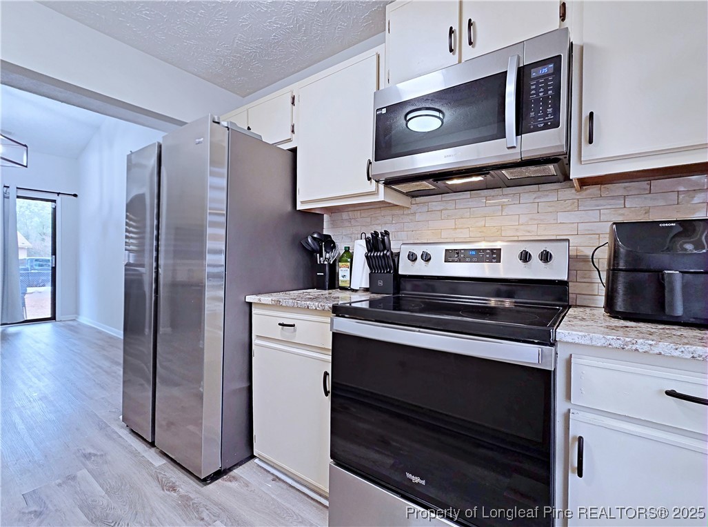 5309 Tory Hill Road Hope Mills, NC 28348 - Photo 15 of 45 a kitchen with stainless steel appliances granite countertop a stove and a microwave