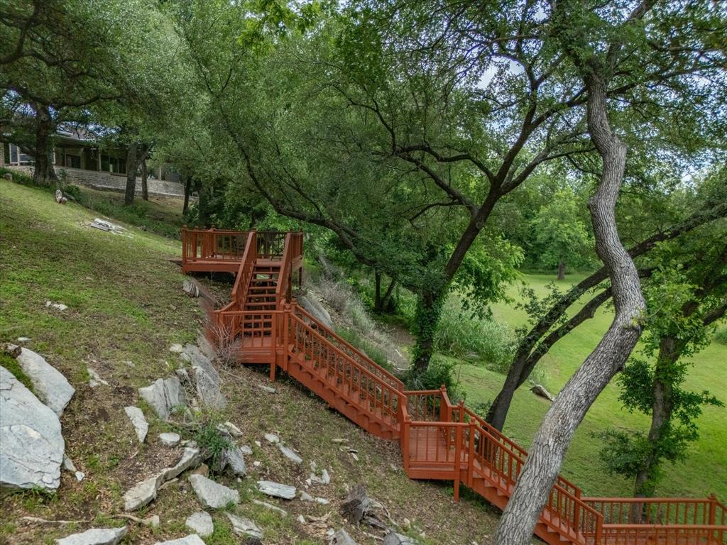 10106 Ravenswood Road Granbury, TX 76049 - Photo 28 of 39 a view of a yard with wooden fence and large trees