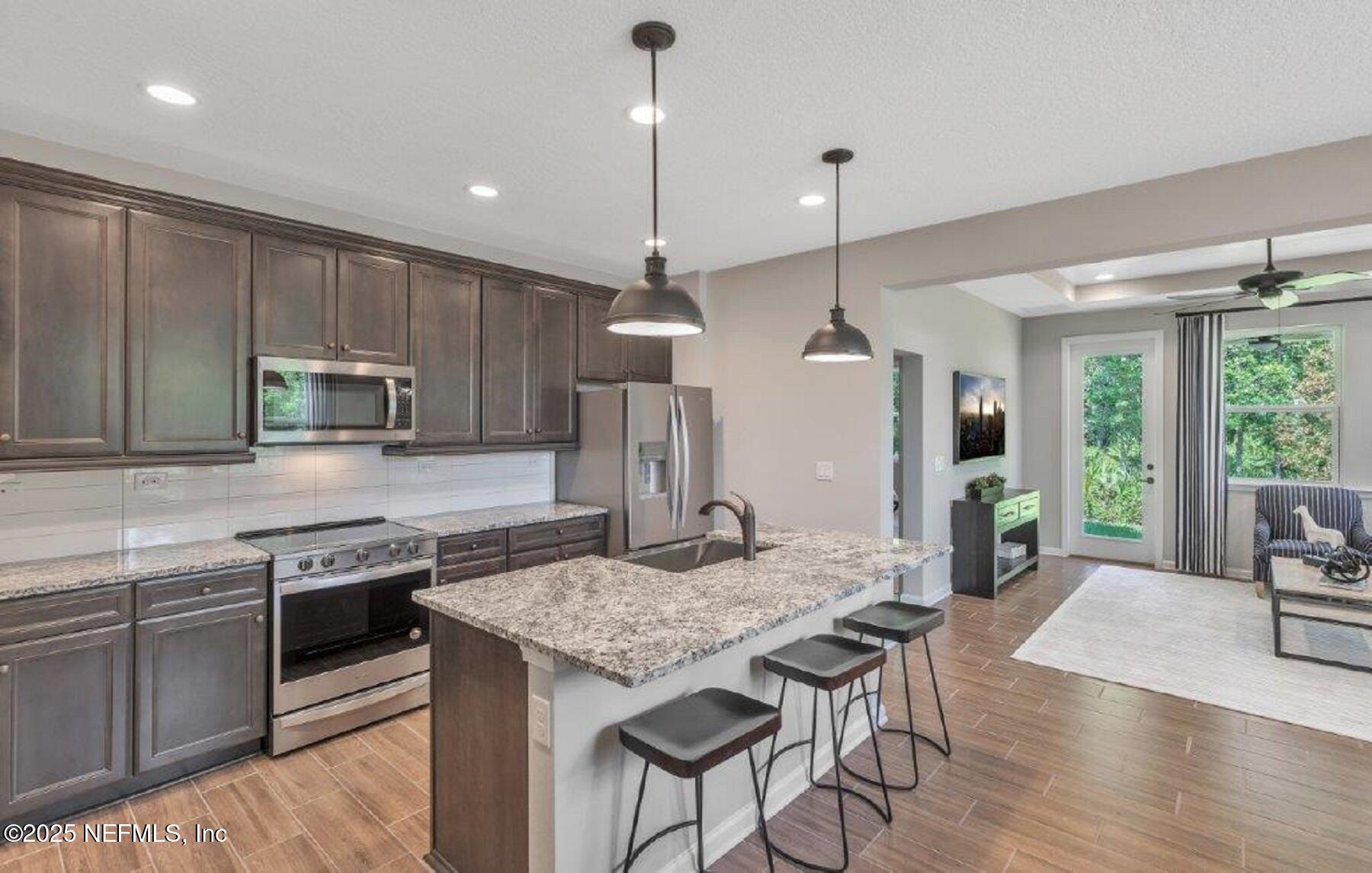 1000 Brk Frst Drive St. Augustine, FL 32092 - Photo 4 of 14 a kitchen with stainless steel appliances granite countertop wooden floor sink stove and refrigerator