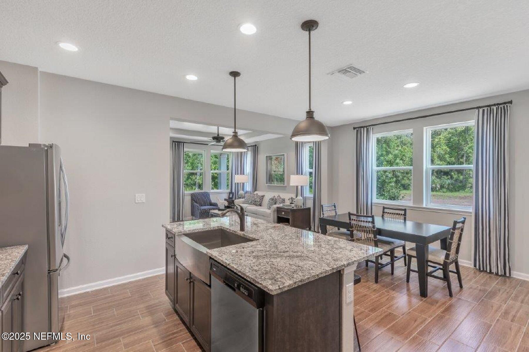 1000 Brk Frst Drive St. Augustine, FL 32092 - Photo 7 of 14 a kitchen with granite countertop kitchen island stainless steel appliances a table chairs sink and wooden floor