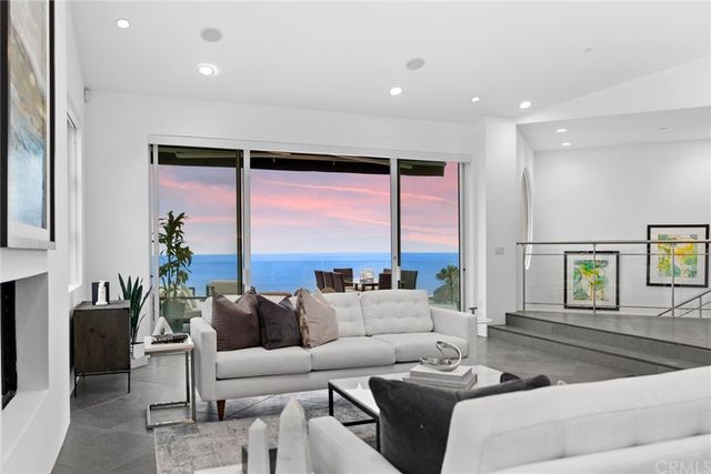 a living room with furniture kitchen view and a large window
