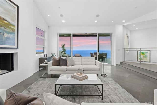 a living room with furniture large windows and a fireplace