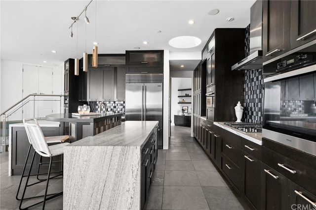 a kitchen with stainless steel appliances granite countertop a sink a stove and a refrigerator