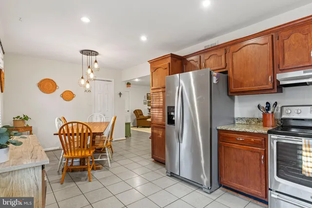 a kitchen with stainless steel appliances granite countertop a refrigerator and a stove top oven