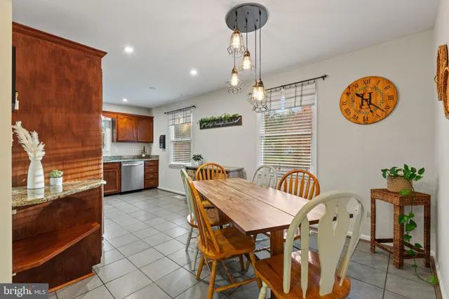 a view of a dining room and livingroom with furniture wooden floor a rug a painting and a chandelier
