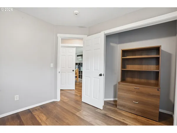 a view of empty room with wooden floor