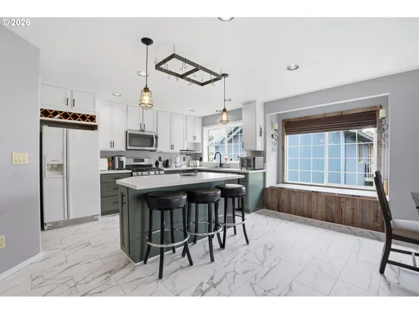 a kitchen with kitchen island a counter top space a sink appliances and cabinets