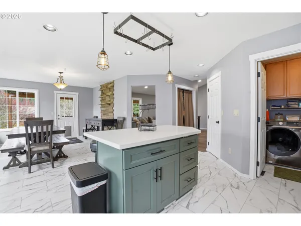 a kitchen with a sink a stove a dining table and chairs