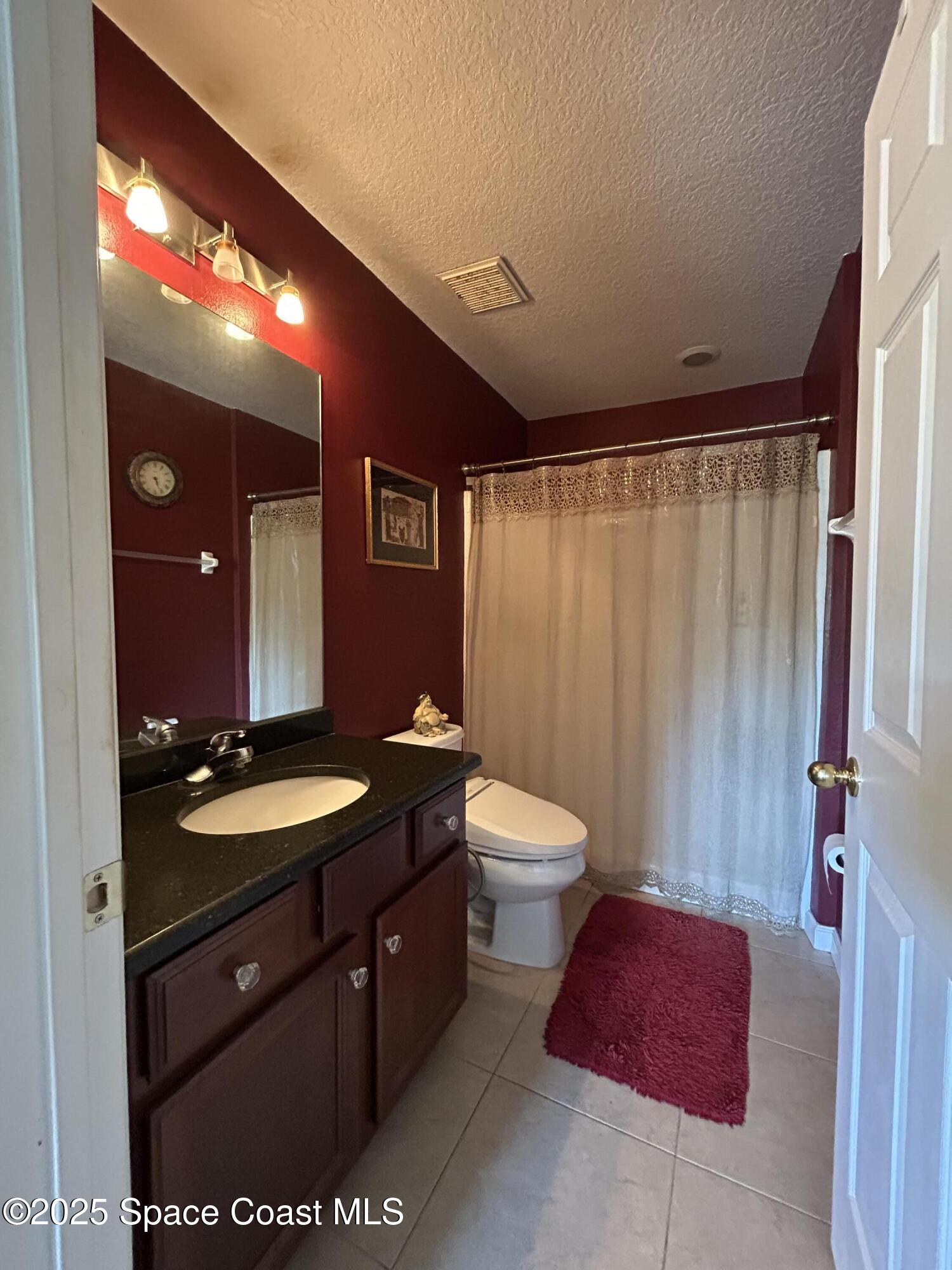 4067 Meander Place, Unit 204 Rockledge, FL 32955 - Photo 13 of 17 a bathroom with a granite countertop sink vanity mirror and toilet