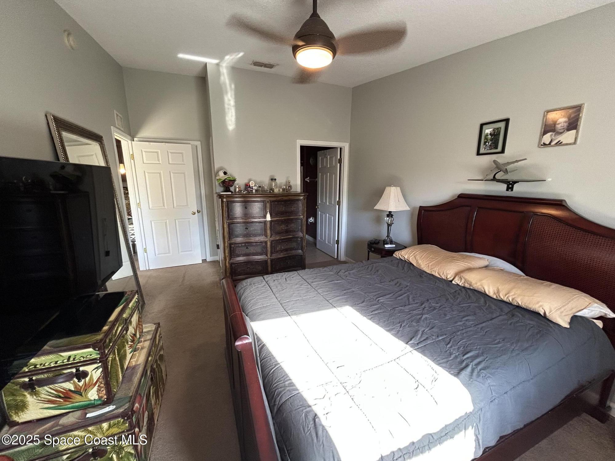 4067 Meander Place, Unit 204 Rockledge, FL 32955 - Photo 14 of 17 a bedroom with a bed and a flat tv screen on dresser