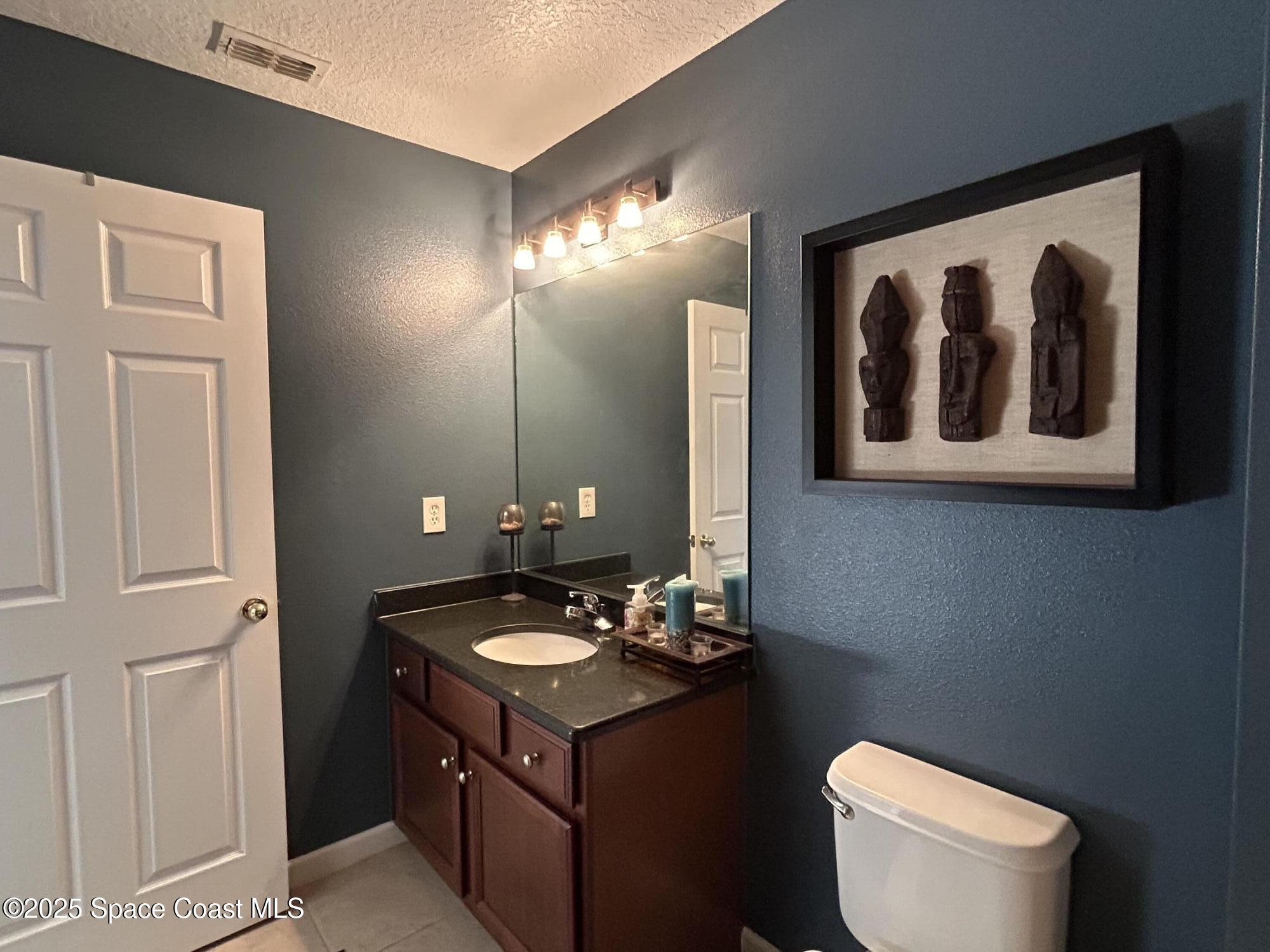 4067 Meander Place, Unit 204 Rockledge, FL 32955 - Photo 10 of 17 a bathroom with a toilet sink and mirror